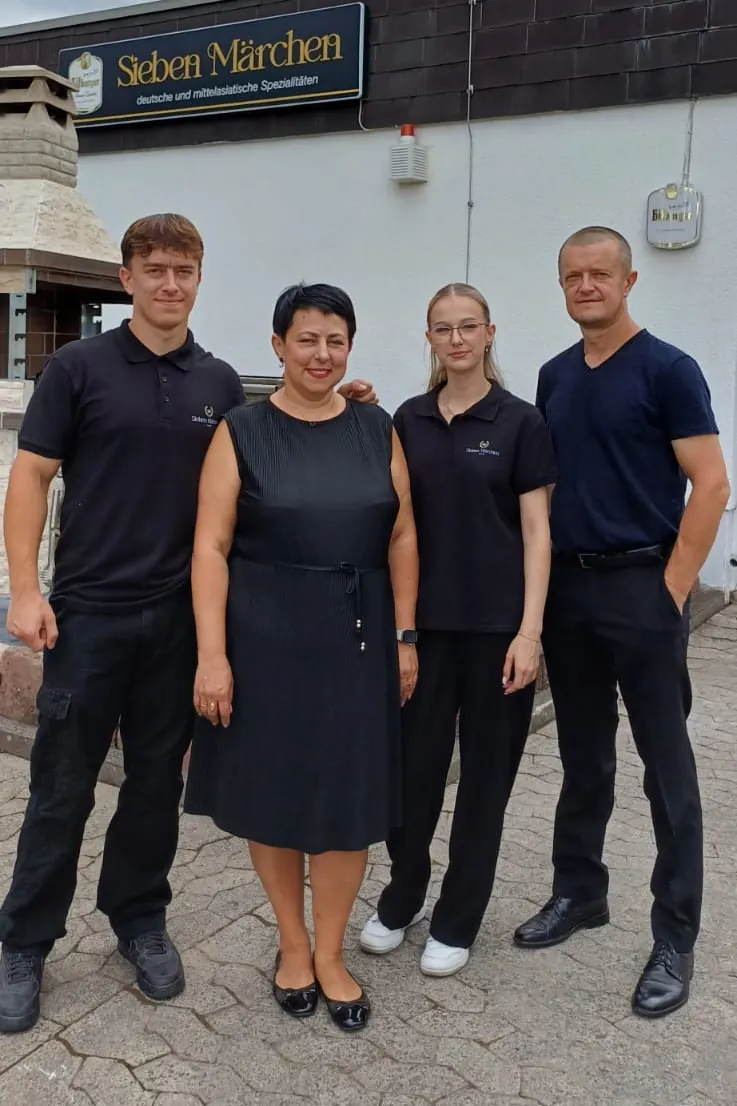 Die Familie, die Sieben Märchen betreibt, vor dem Restaurant