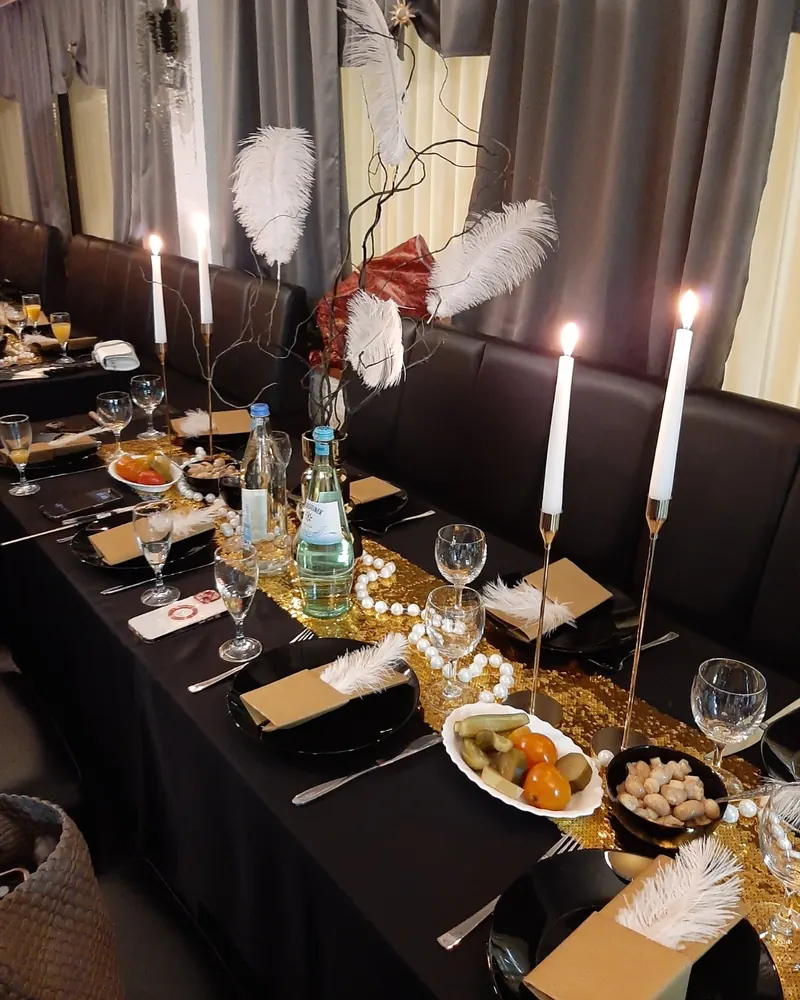Lange Tafel für eine Feier, mit Kerzen, Federn und Vorspeisen