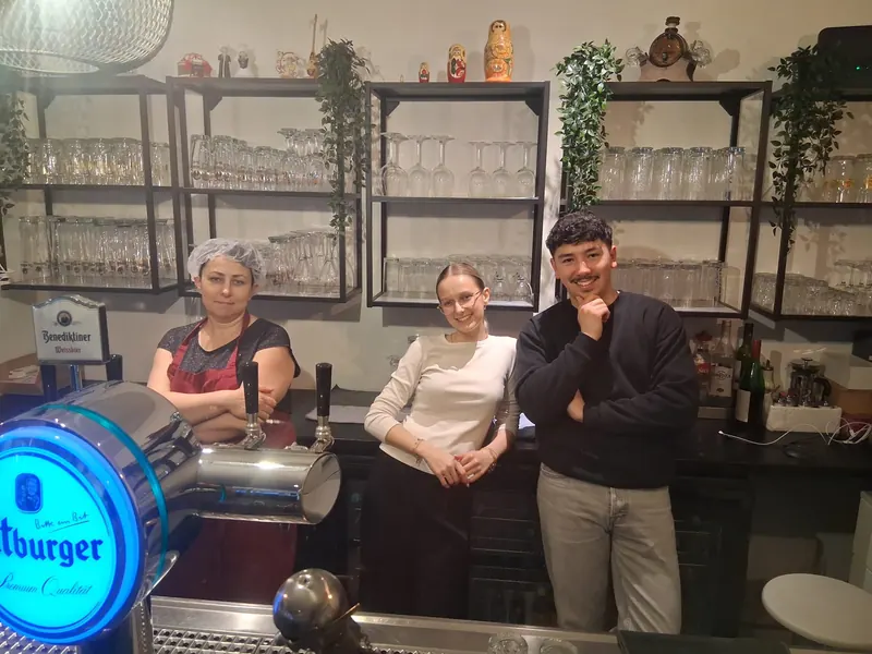 Drei Mitarbeiterinnen und Mitarbeiter an der Bar