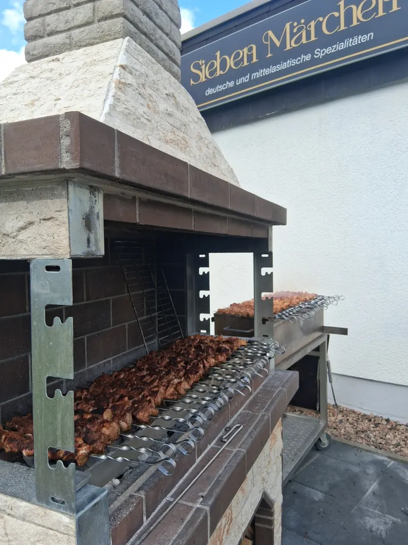 Grillofen mit Spießen vor dem Schild Sieben Märchen