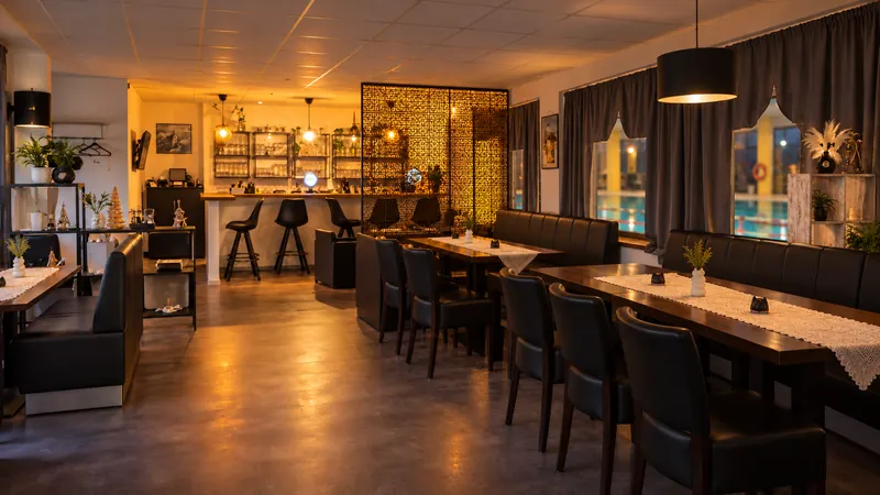Der Gastraum von Sieben Märchen am Abend, mit Bar, Lederbänken und Raumteiler