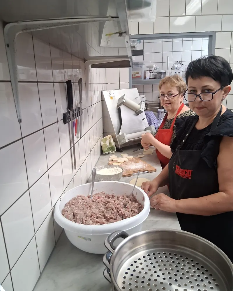 Zwei Köchinnen bereiten in der Küche Hackfüllung für Teigtaschen vor