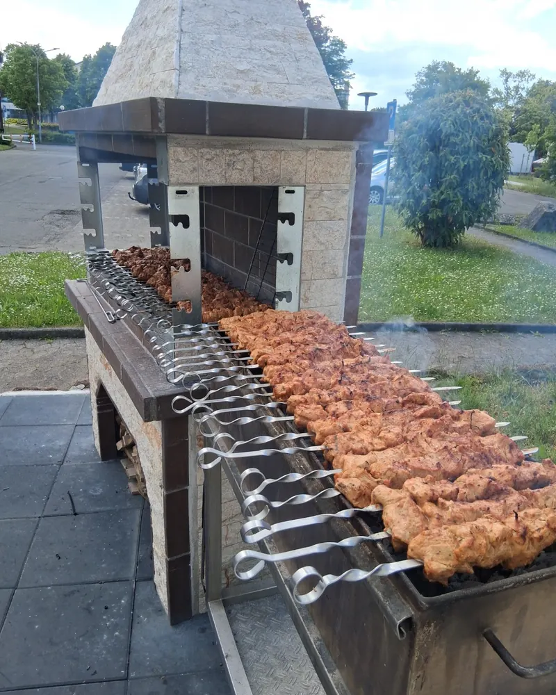 Schaschlik-Spieße auf dem Mangal vor dem gemauerten Grillofen